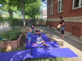 Kinder turnen auf Yogamatten im Freien