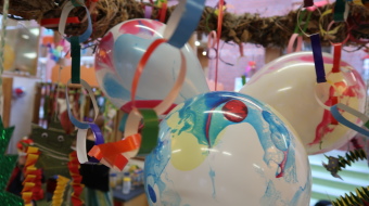 bunte Luftballons, dekoriert mit Luftschlangen an einem Kranz hängend