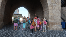 Kindergruppe steht unter dem Torbogen